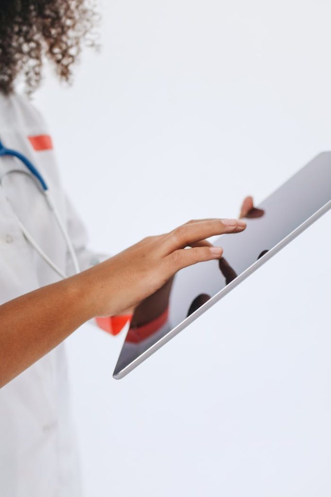 a-doctor-using-a-tablet-5234506 Close-up of a doctor using a tablet for medical records in a professional setting.