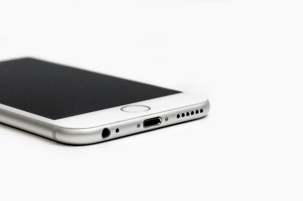 close-up-of-mobile-phone-against-white-background-249324 Minimalist image of a sleek smartphone with focus on the bottom edge and ports.